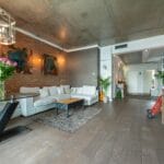 Jasny salon w stylu loft z dużą sofą i industrialnymi dodatkami