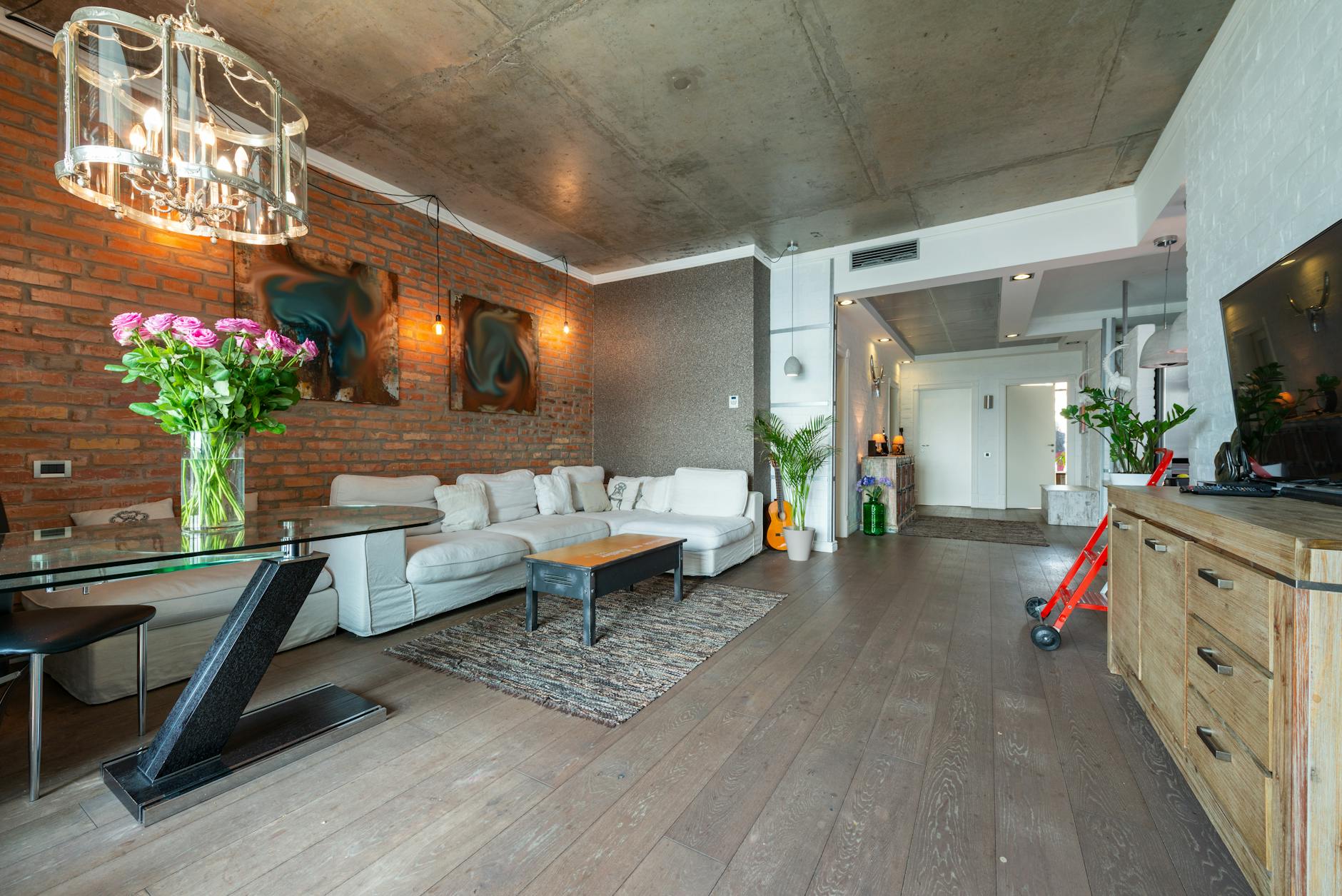 Jasny salon w stylu loft z dużą sofą i industrialnymi dodatkami
