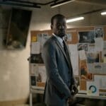 Mężczyzna w garniturze analizuje tablicę z notatkami w biurze