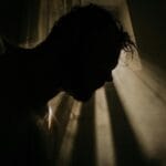 Mroczna sylwetka mężczyzny w cieniu, jak z thrillera psychologicznego