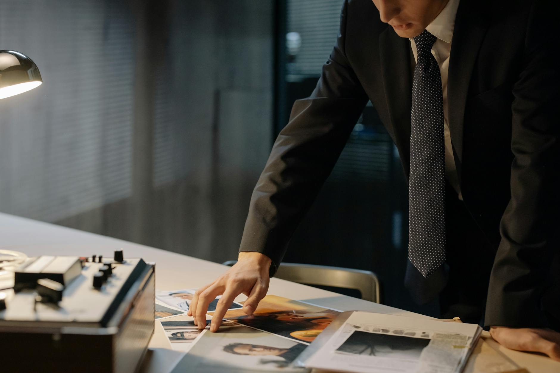 Śledczy nocą analizuje zdjęcia dowodów w biurze