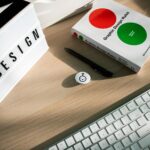 Biurko grafika z książką o designie, klawiaturą i świecącym hashtagiem