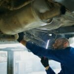 Mechanik wykonuje przegląd podwozia auta w warsztacie