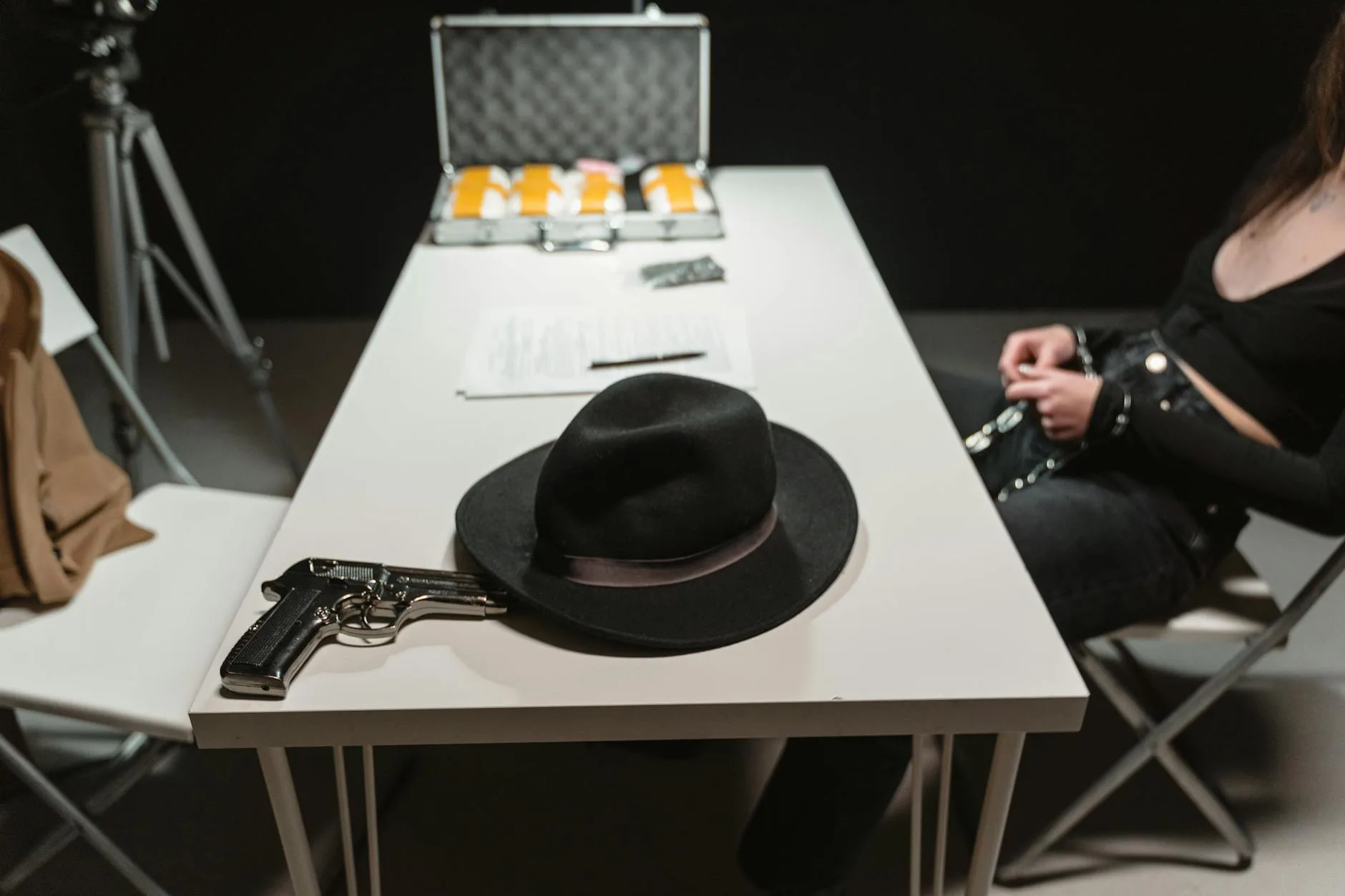 Pistolet i kapelusz na stole w pokoju przesłuchań sugerującym zbrodnię