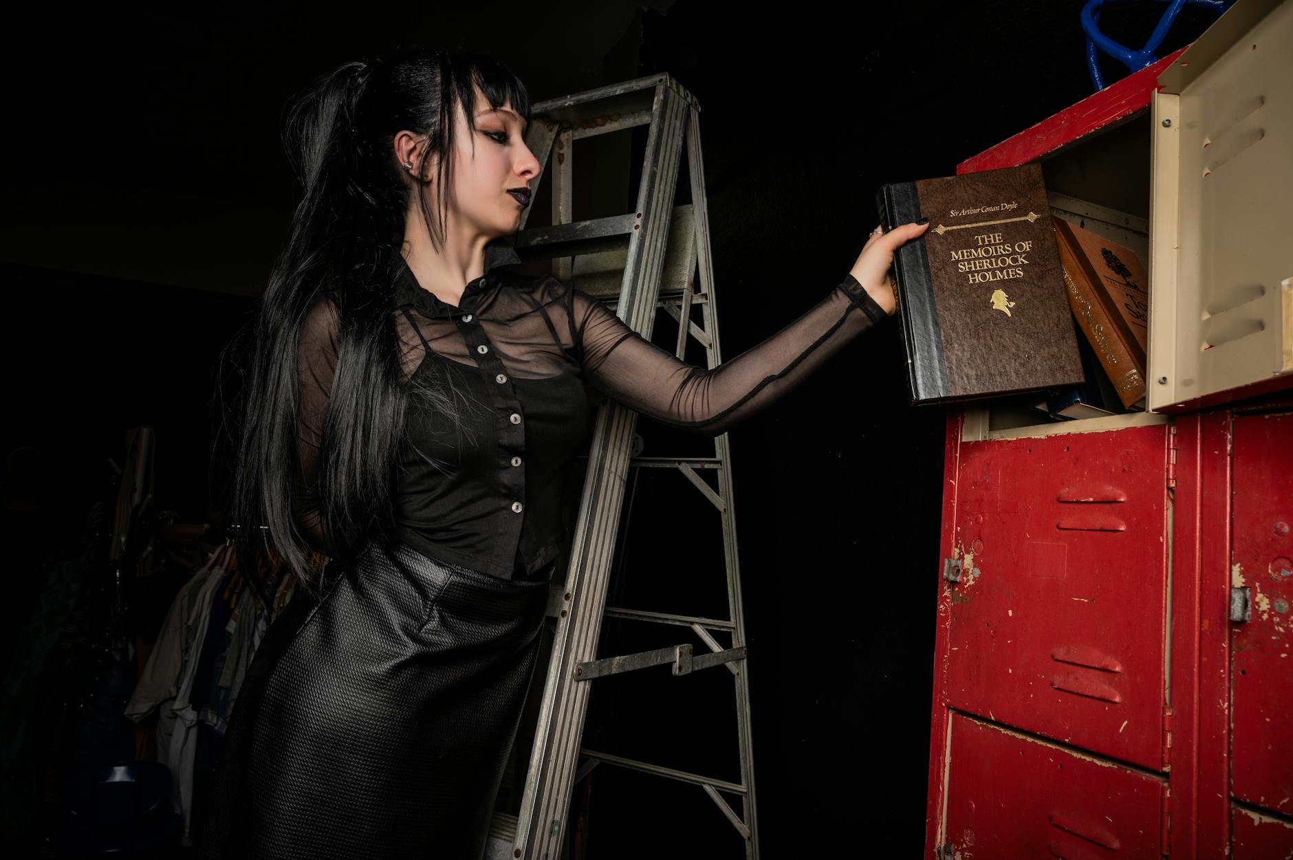 Kobieta o gotyckim wyglądzie sięga po książkę Sherlocka Holmesa w bibliotece