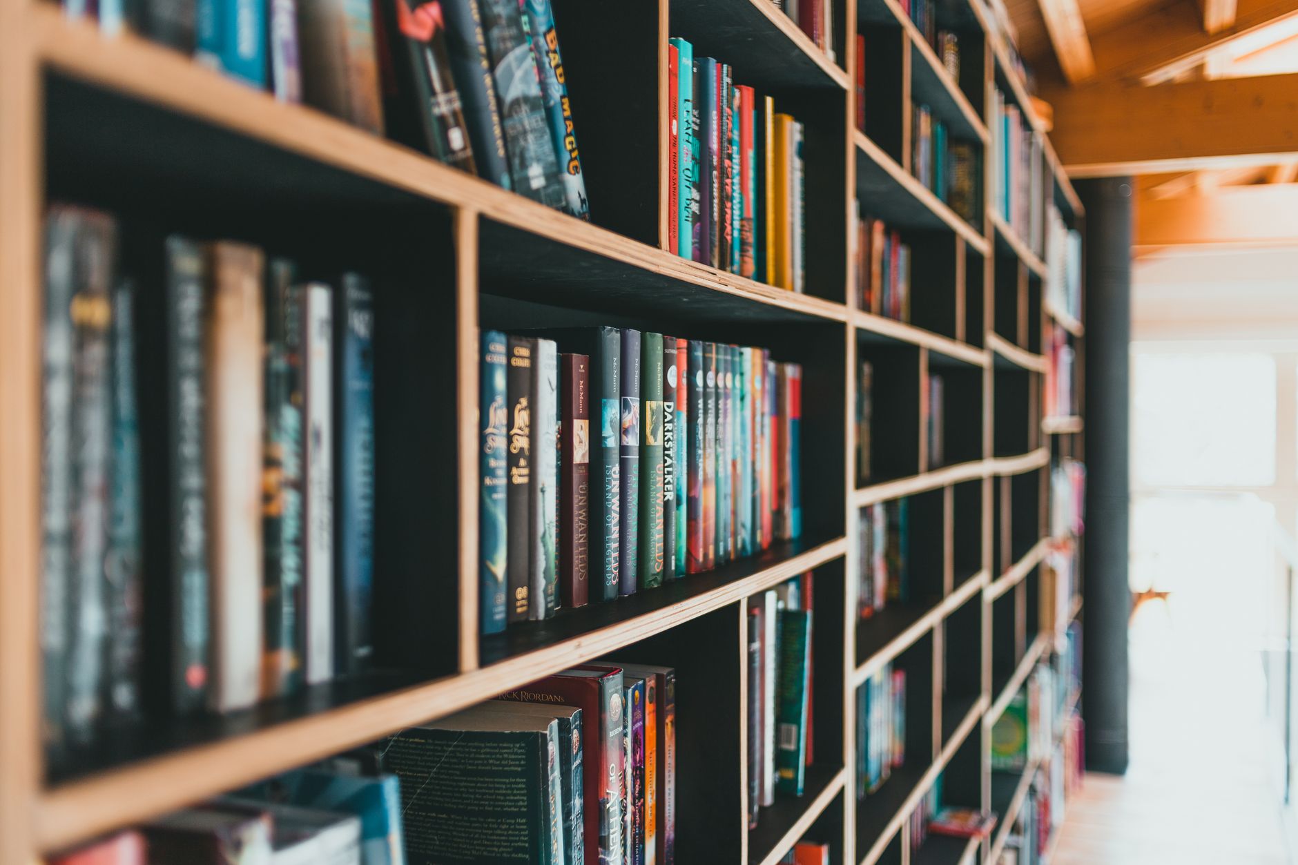 Kolorowe książki na nowoczesnych regałach w jasnej bibliotece